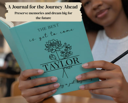 A person is holding a turquoise journal with the title "The Best is yet to Come" and the name "Taylor" printed on it.