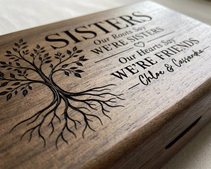 A wooden box with a tree design and text engraved on it.