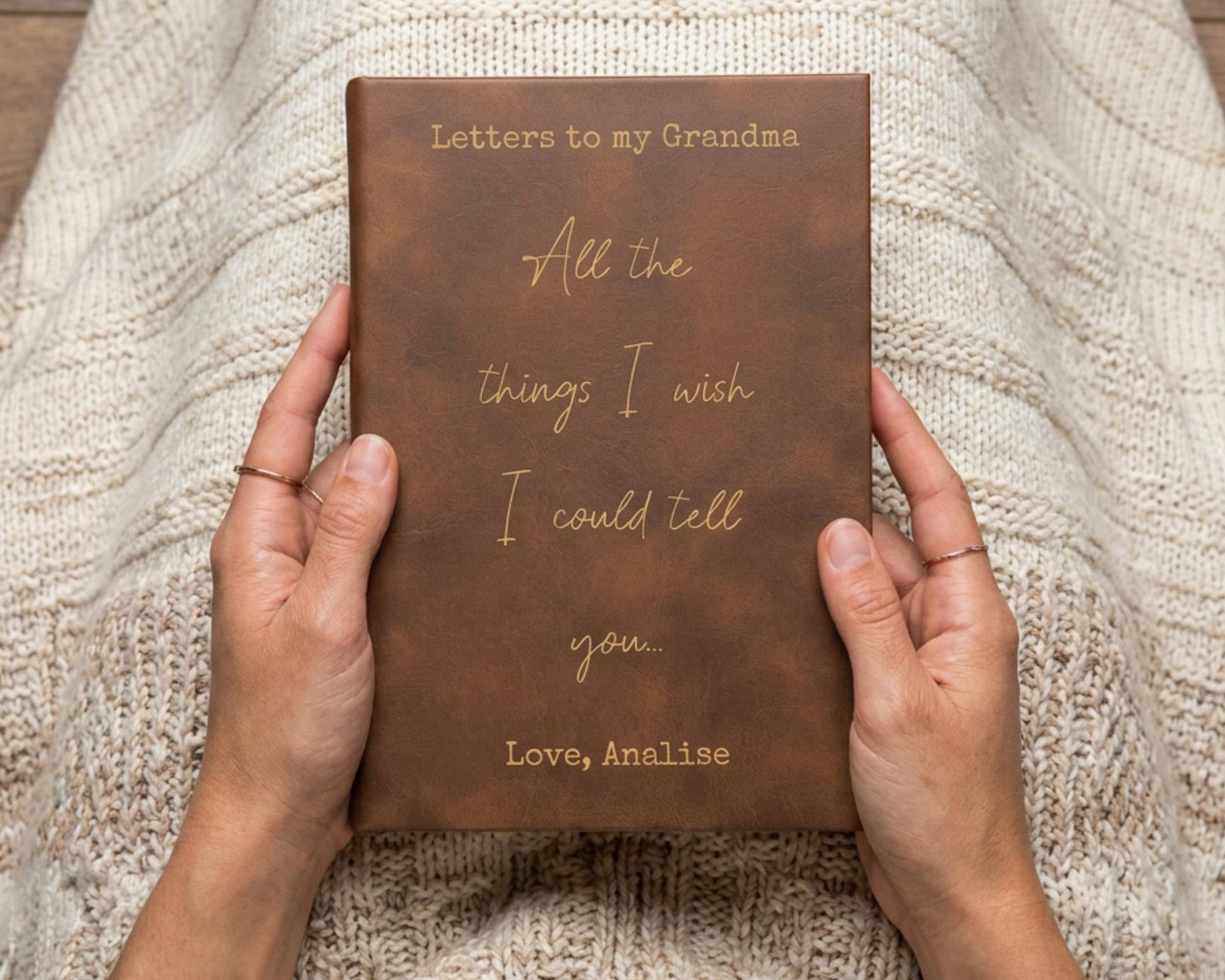 A person's hands holding a brown leather-bound book titled "Letters to my Grandma All the things I wish I could tell you."