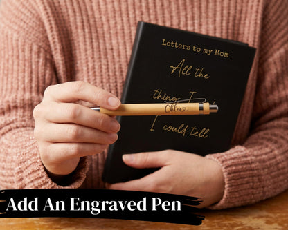 A person is holding a black notebook with the words "Letters to my Mom" written on it, and a wooden pen with the words "All the things I could tell" engraved on it.