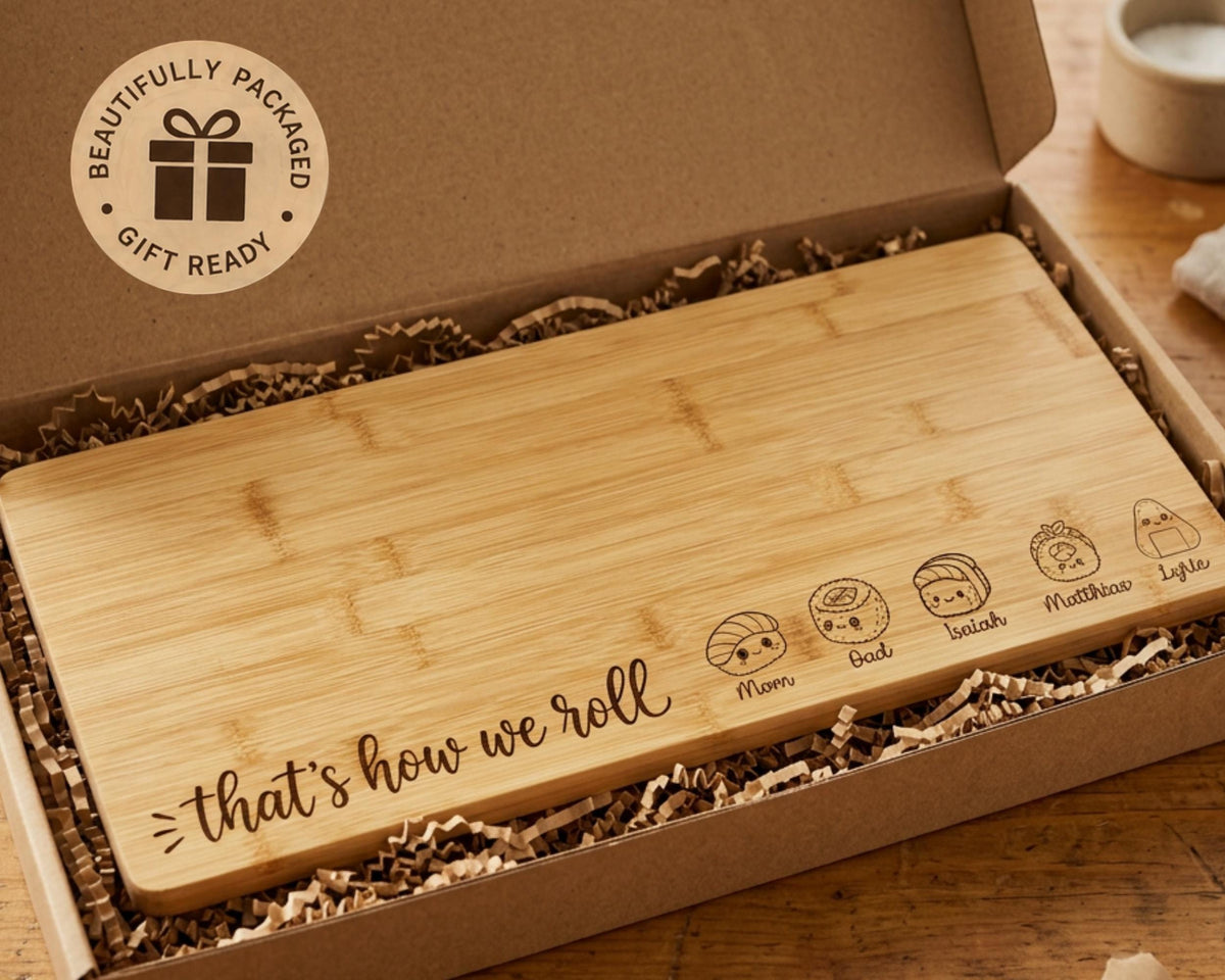 A wooden cutting board with a humorous message engraved on it, placed in a cardboard box with shredded paper.