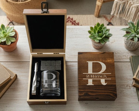 a wooden box with a glass and a toothbrush inside, along with a potted plant and a book on a wooden surface.