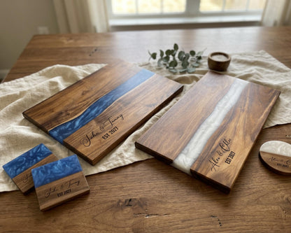 a wooden table with two wooden cutting boards, each with a blue and white design, and several small wooden coasters. There is also a small plant and a candle on the table.
