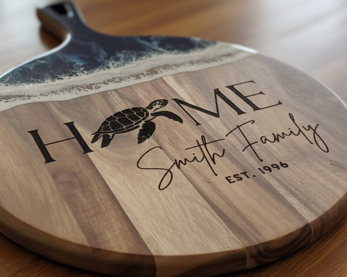 A wooden cutting board with a black and white turtle design and the text "HOME Smith Family" printed on it.