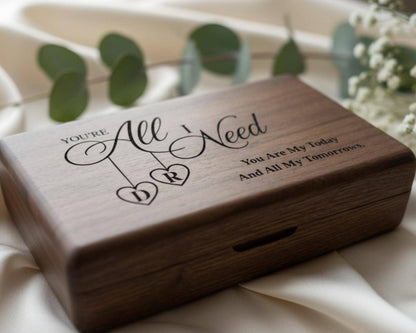 A wooden box with a personalized message engraved on it, sitting on a white cloth.
