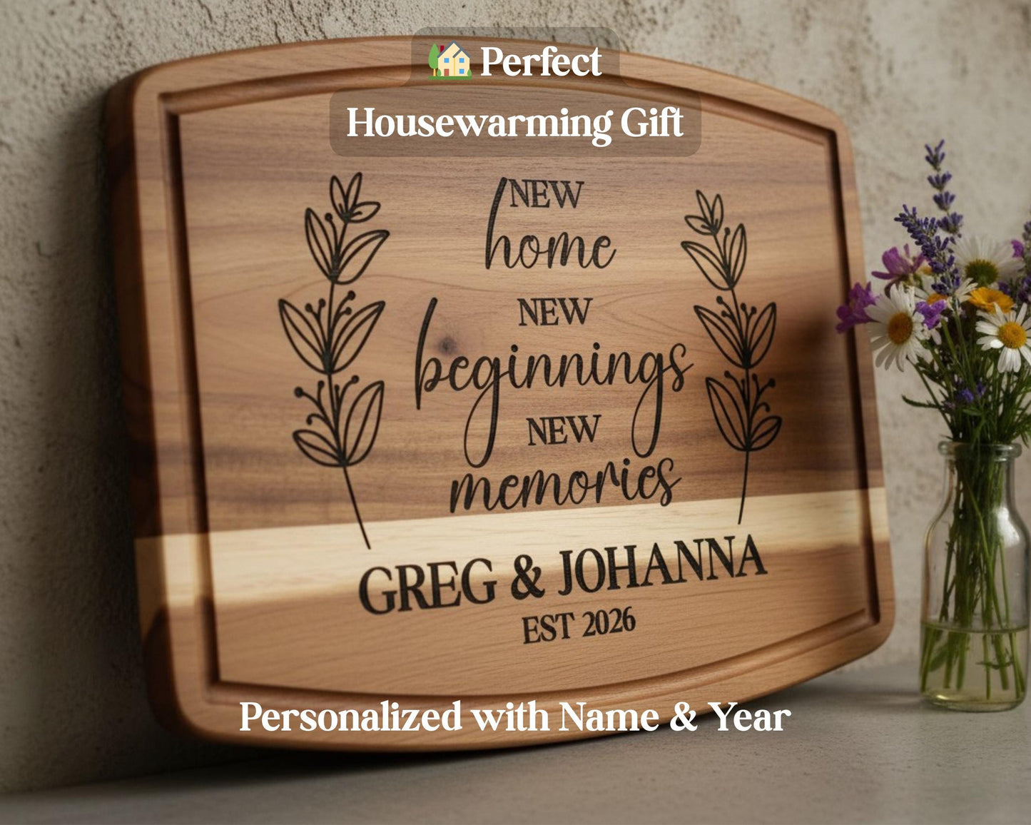 A wooden cutting board with a personalized message engraved on it, along with a vase of flowers and a housewarming gift sign.