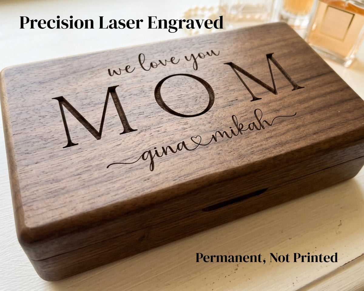 A wooden box with the engraved message "Precision Laser Engraved we love you Mom gina & mikah" on it.