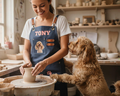 A woman is making pottery in a pottery studio, while a dog watches her intently.
