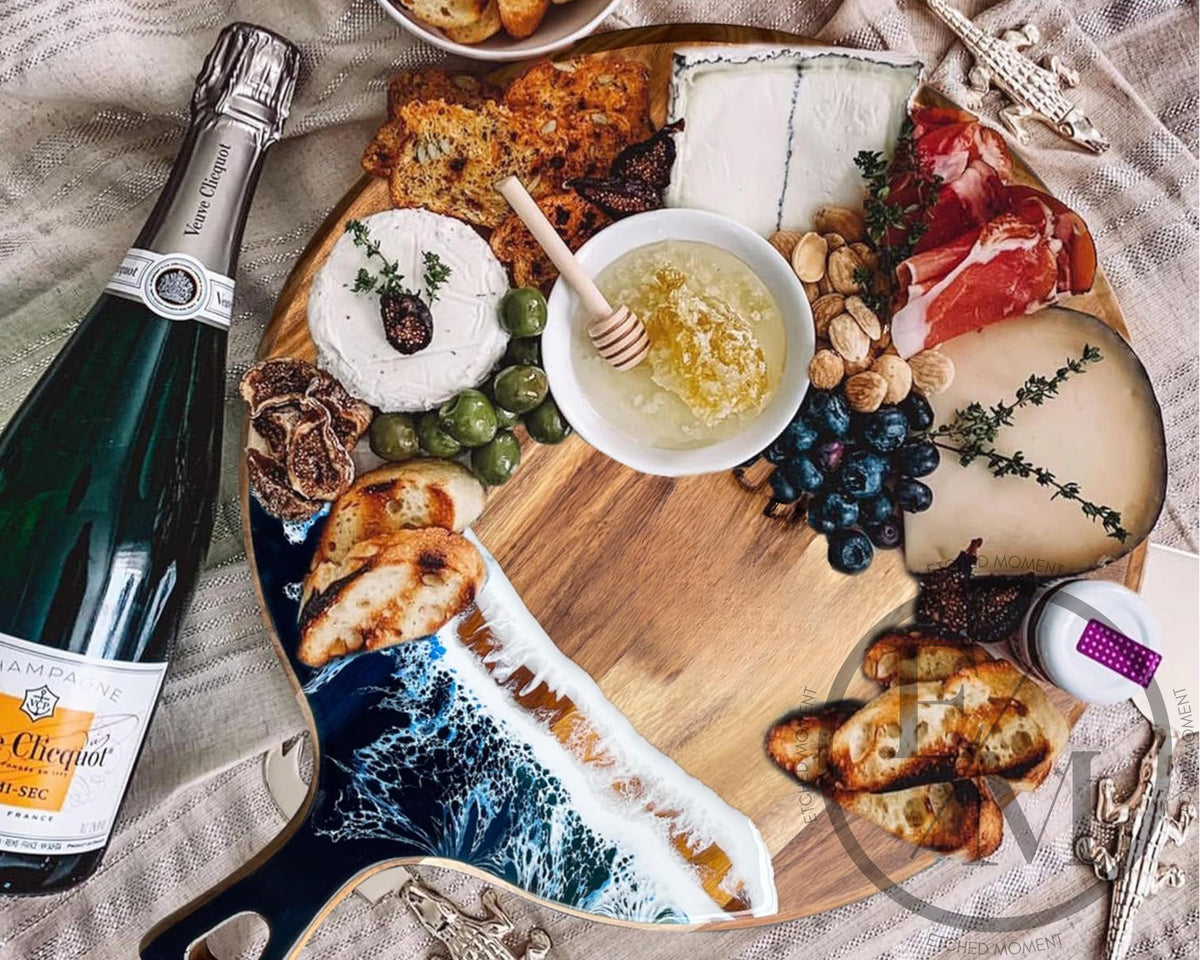 a cheese and cracker platter with various cheeses, meats, and vegetables arranged on a wooden board. A bottle of champagne is also present on the table.