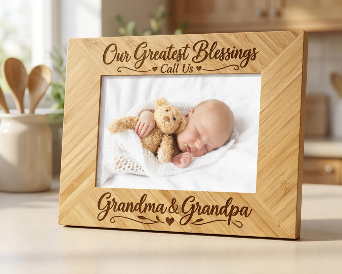 A wooden picture frame with a photo of a sleeping baby and a teddy bear inside. The frame has a message that reads "Our Greatest Blessings Call Us Grandma & Grandpa".