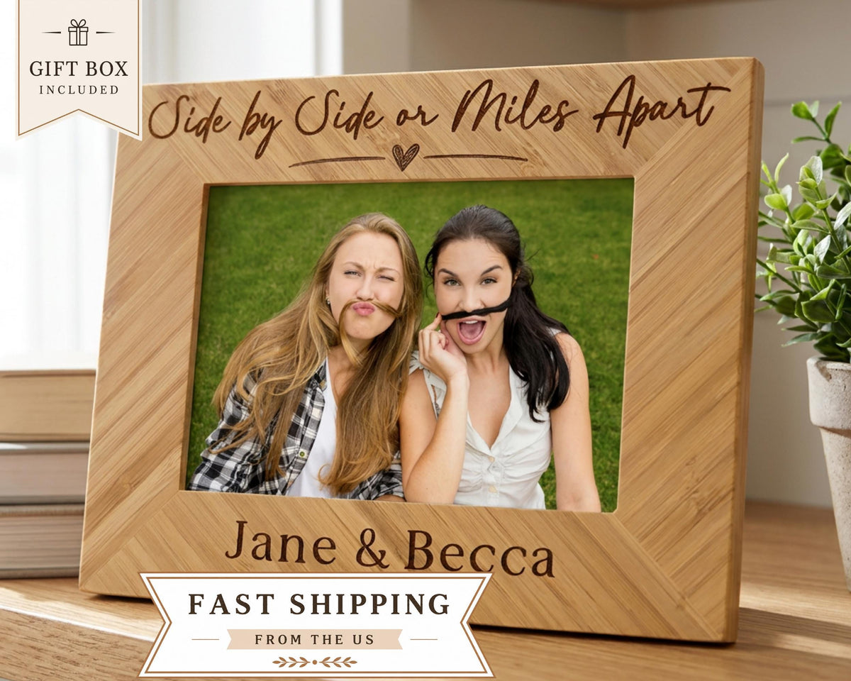 A wooden picture frame with two women making silly faces, posing for a photo. The frame has a message that says "Side by Side or Miles Apart" and "Jane & Becca" written on it. The image also includes a text that says "Gift Box Included" and "Fast Shipping from the US".