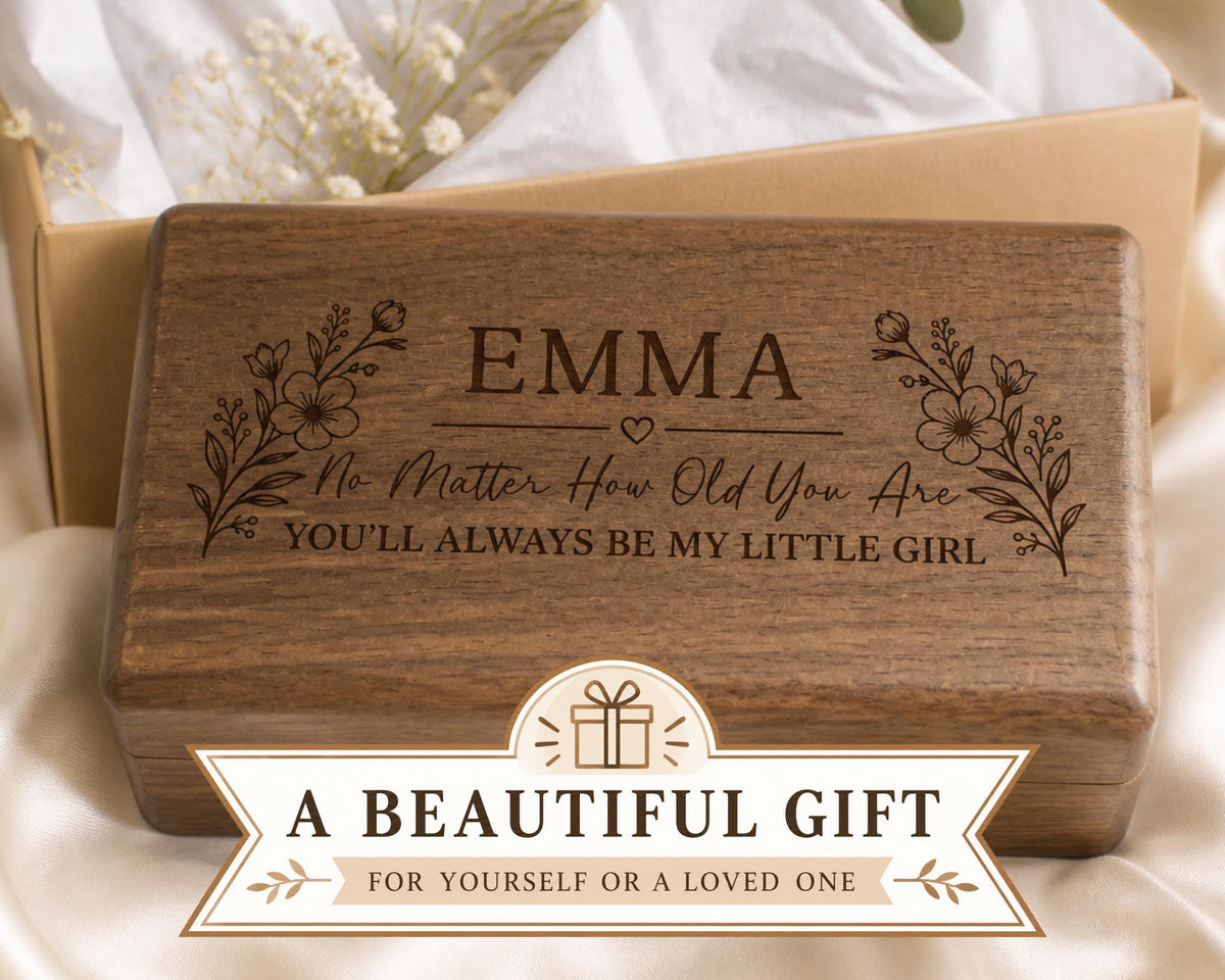 A wooden box with a personalized message engraved on it, placed on a white cloth.