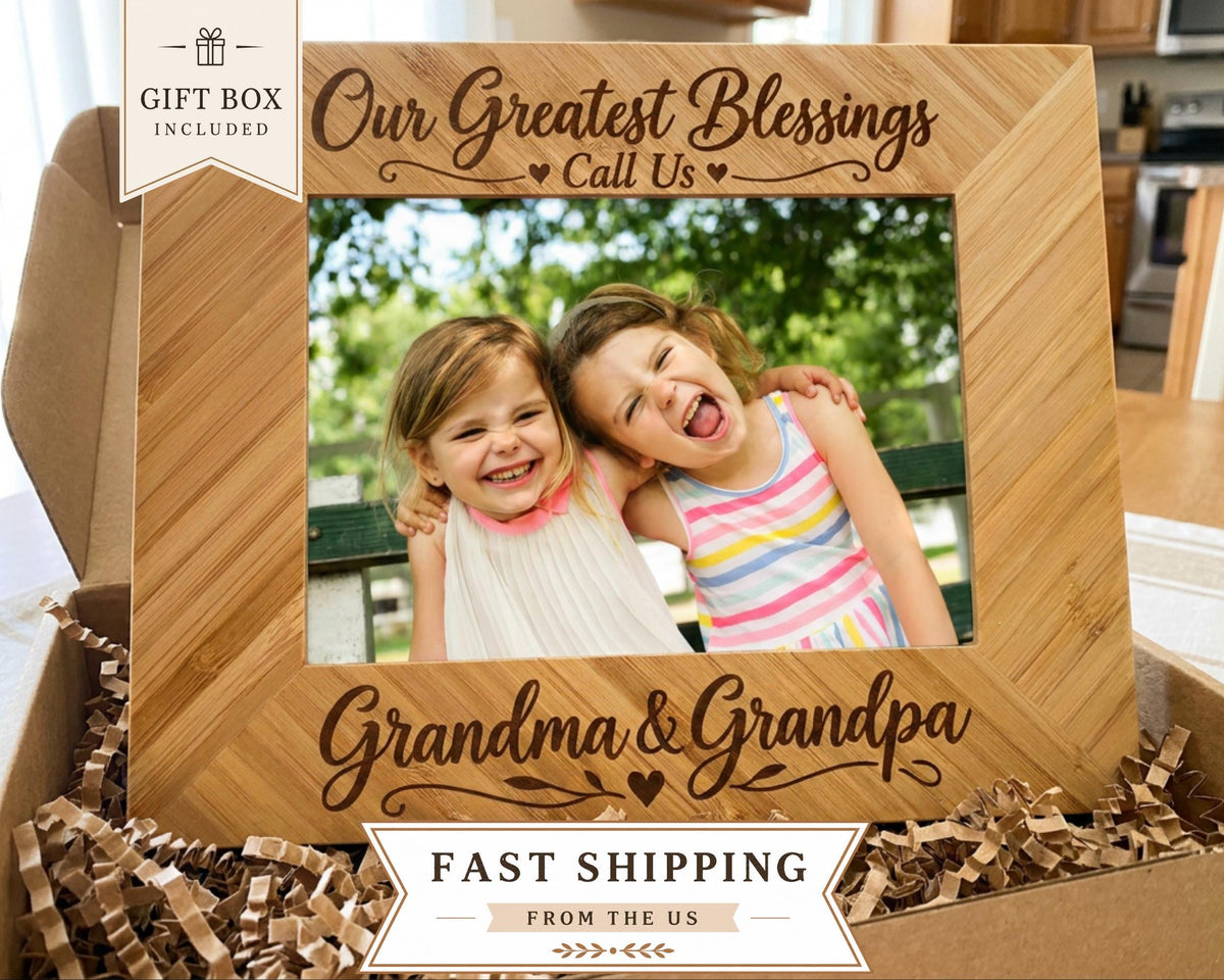 A wooden picture frame with a photo of two young girls inside, surrounded by shredded paper. The frame has a message that reads "Our Greatest Blessings Call Us Grandma & Grandpa".