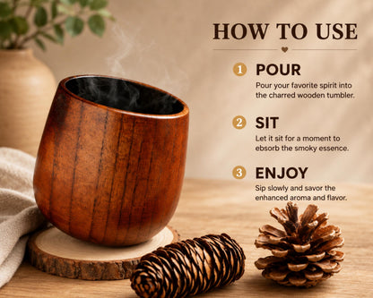 a wooden tumbler with a steaming hot beverage inside, accompanied by a pine cone and a wooden coaster on a wooden surface. The image also includes text instructions for using the tumbler, including pouring a favorite spirit, sitting, and enjoying the aroma and flavor.