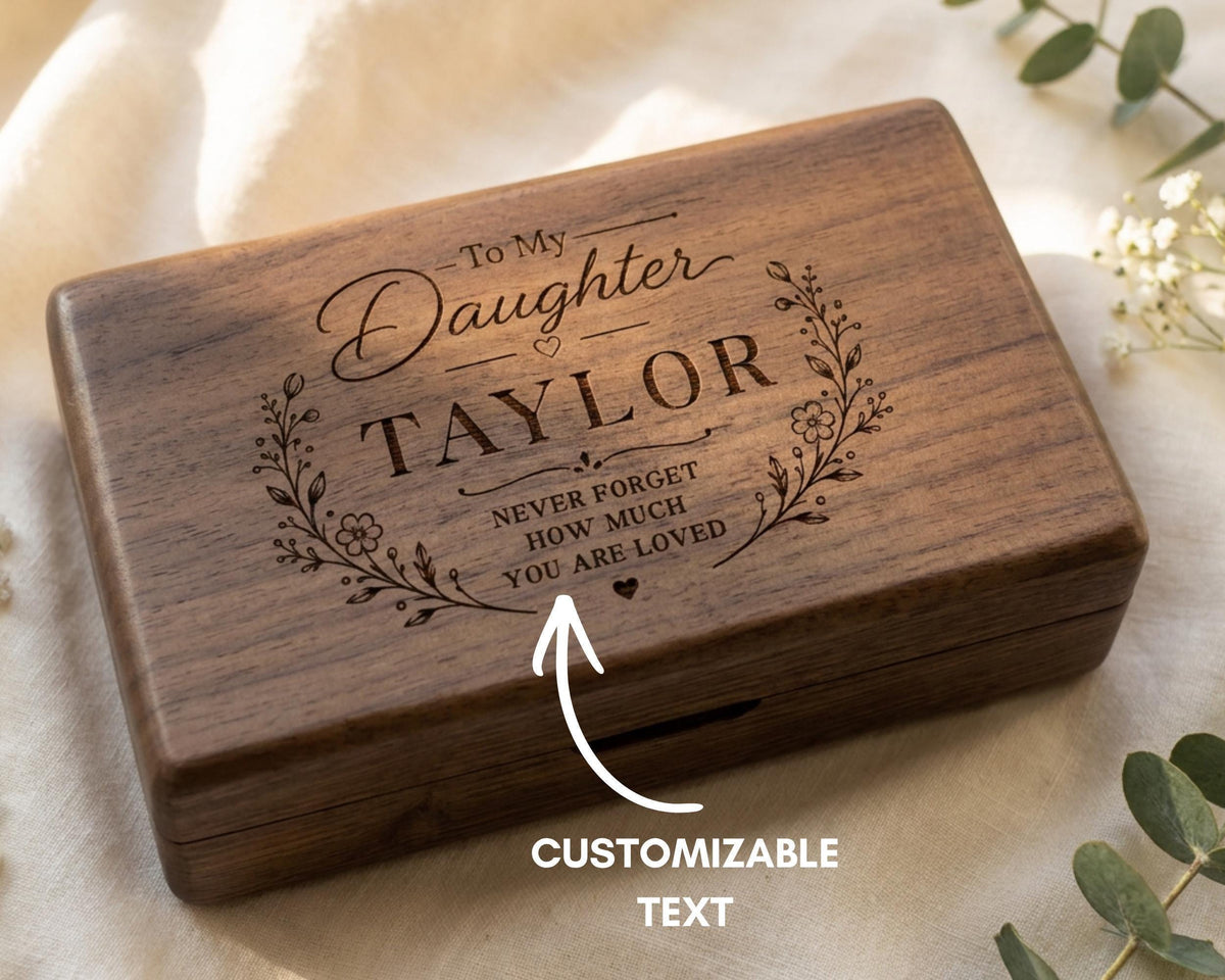 A wooden box with a personalized message engraved on it, along with a note indicating that it is customizable text.