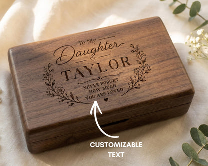 A wooden box with a personalized message engraved on it, along with a note indicating that it is customizable text.