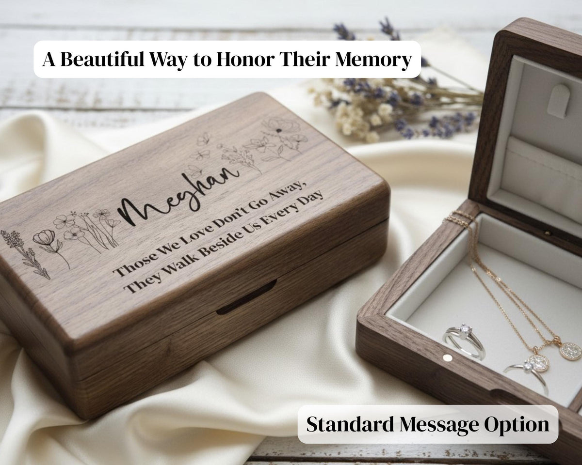 A wooden jewelry box with a personalized message engraved on it, placed on a white cloth.